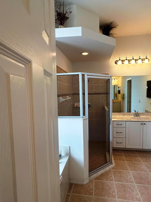 bathroom featuring tile patterned floors, vanity, and shower with separate bathtub