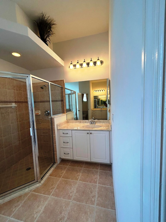 bathroom with tile patterned flooring, vanity, and a shower with shower door