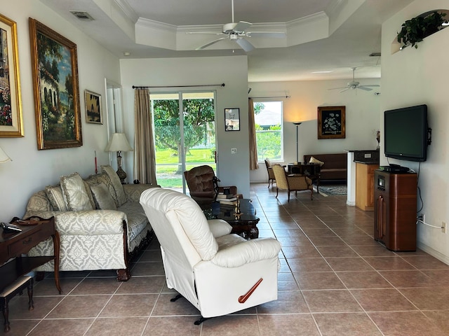 living room with ceiling fan, tile patterned floors, and a tray ceiling