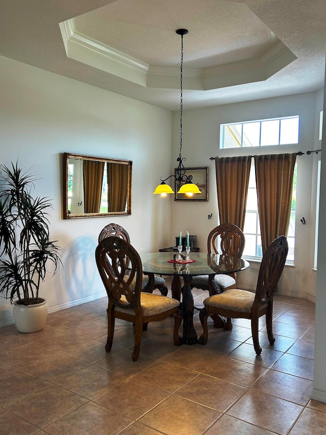 tiled dining room with a raised ceiling and ornamental molding