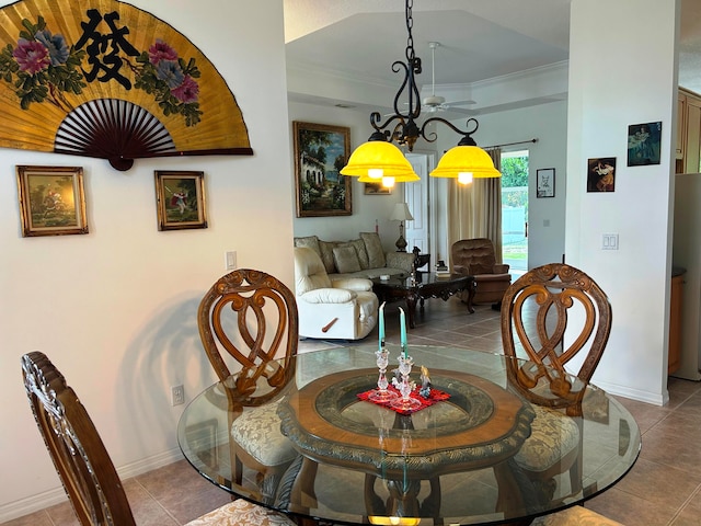 dining space with tile patterned flooring and a raised ceiling