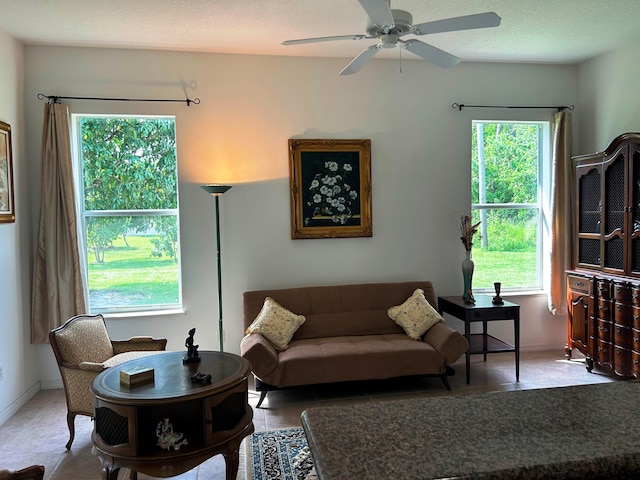 tiled living room with ceiling fan and a healthy amount of sunlight