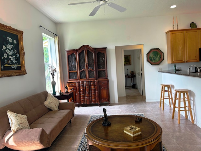 tiled living room featuring sink and ceiling fan