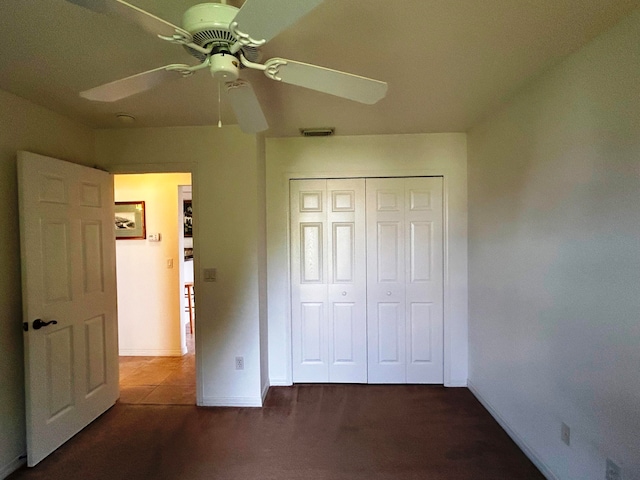 unfurnished bedroom with ceiling fan, a closet, and carpet floors