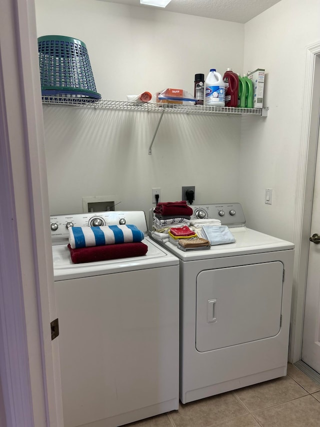 laundry room featuring light tile patterned flooring and washing machine and clothes dryer