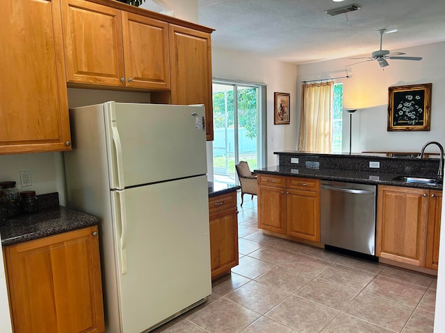 kitchen featuring stainless steel dishwasher, sink, ceiling fan, light tile patterned flooring, and white refrigerator