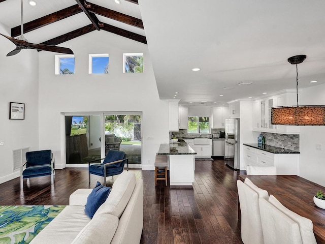 living room featuring beam ceiling, high vaulted ceiling, dark hardwood / wood-style floors, and sink