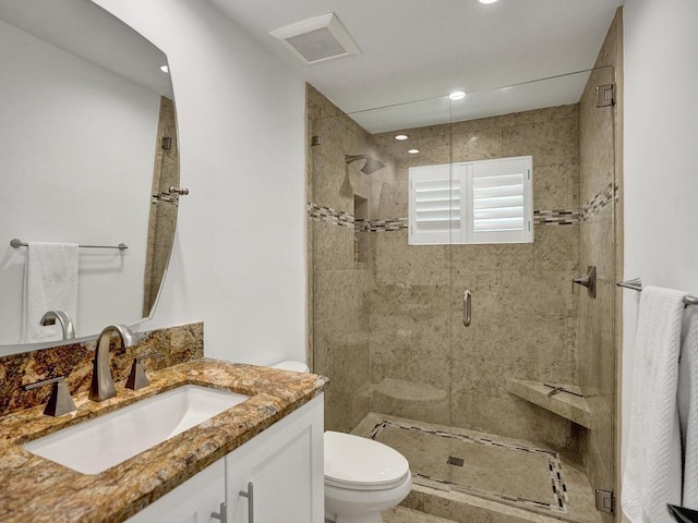 bathroom with toilet, a shower with door, and vanity