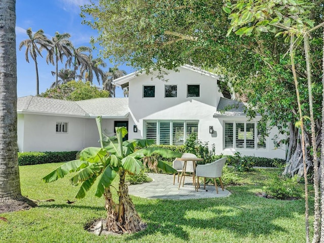 rear view of property with a yard and a patio area