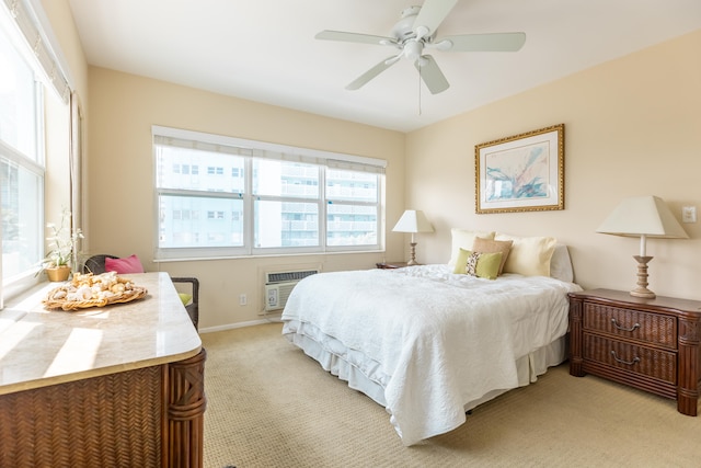 bedroom with light carpet, ceiling fan, and a wall mounted AC