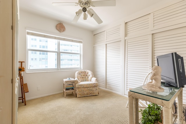 sitting room featuring ceiling fan and carpet