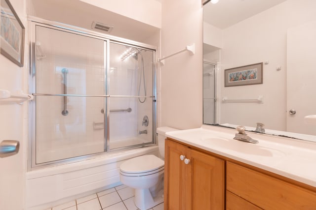 full bathroom with shower / bath combination with glass door, oversized vanity, tile floors, and toilet