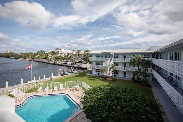 view of pool featuring a water view and a yard