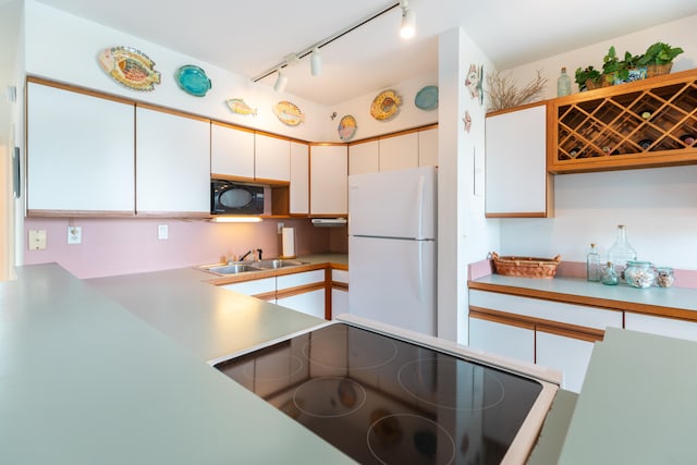 kitchen with rail lighting, white cabinets, black appliances, and sink