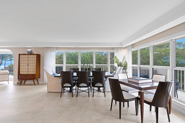 tiled dining room featuring ornamental molding and plenty of natural light