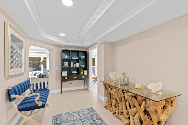 interior space with a tray ceiling, light tile flooring, and crown molding