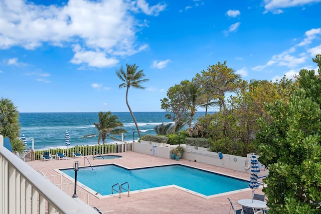 view of pool with a patio and a water view