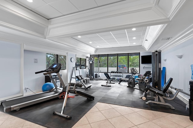 gym featuring light tile floors, plenty of natural light, crown molding, and a raised ceiling