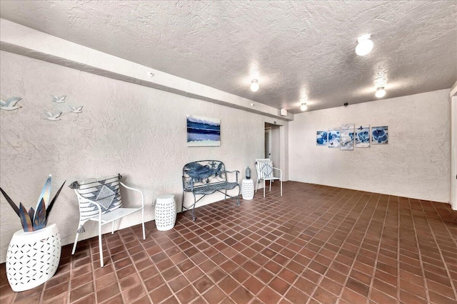 living area featuring dark tile floors and a textured ceiling