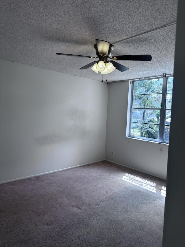 carpeted spare room with ceiling fan and a textured ceiling