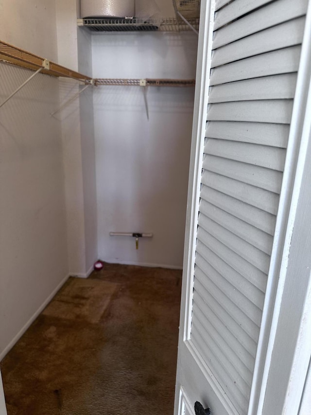 spacious closet featuring dark colored carpet