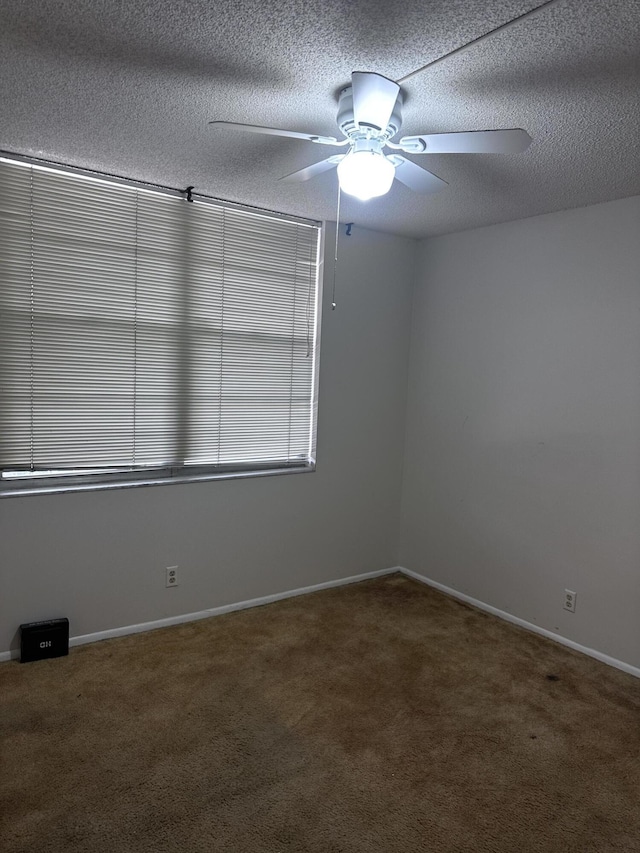 empty room with a textured ceiling, ceiling fan, and carpet floors