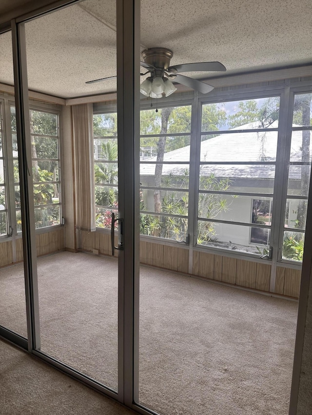 unfurnished sunroom featuring ceiling fan