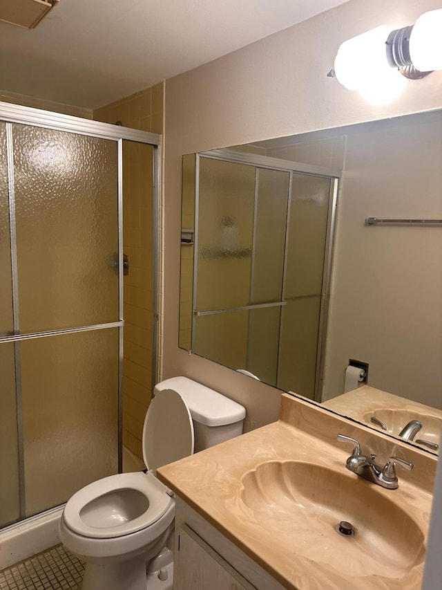 bathroom with toilet, walk in shower, vanity, and tile patterned flooring