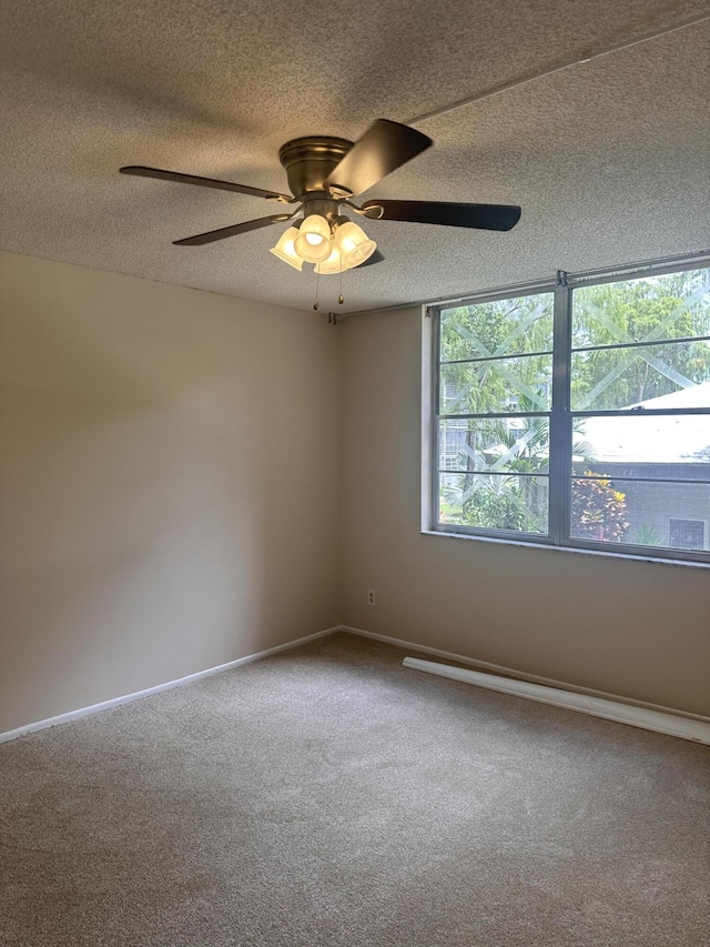 carpeted empty room featuring a textured ceiling and ceiling fan