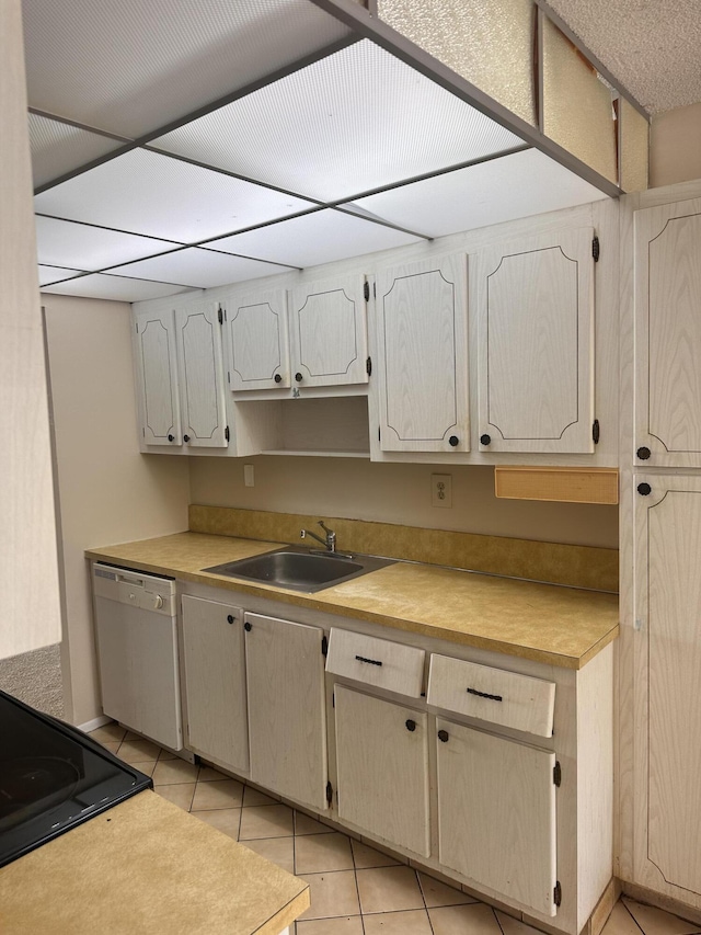 kitchen with electric stove, light tile patterned floors, white dishwasher, and sink