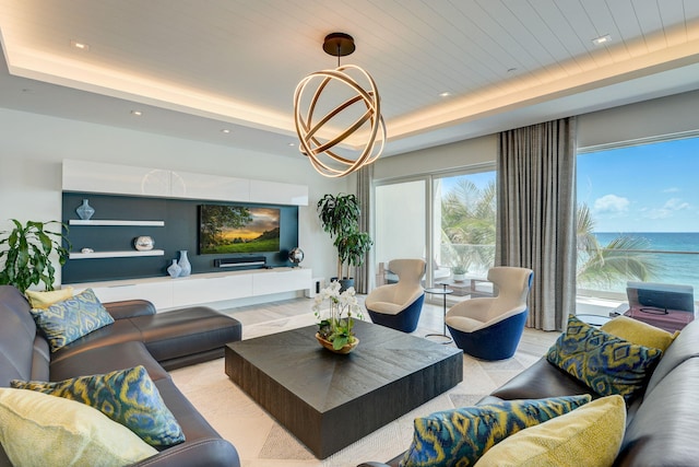 living room with a water view, a tray ceiling, and wood ceiling