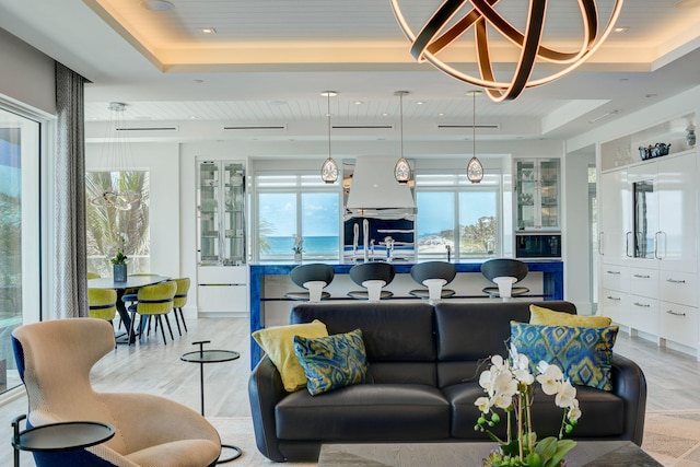 tiled living room featuring a tray ceiling and a wealth of natural light