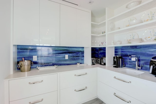 interior space featuring sink and white cabinetry