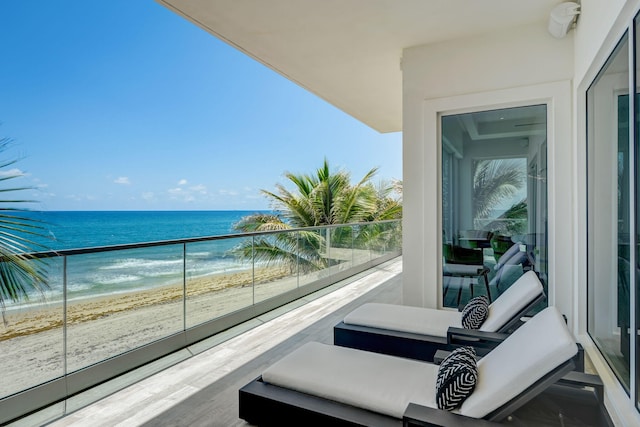 balcony featuring outdoor lounge area, a view of the beach, and a water view