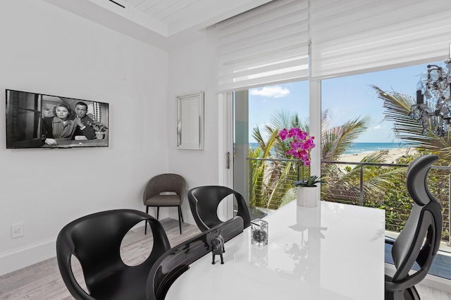 dining area with light hardwood / wood-style flooring and a water view