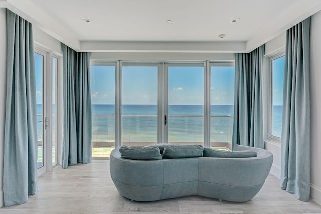 living room with light hardwood / wood-style floors and a water view