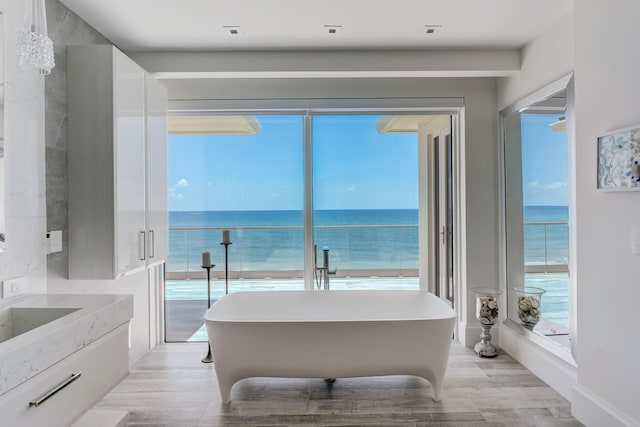 bedroom featuring light hardwood / wood-style flooring and a water view