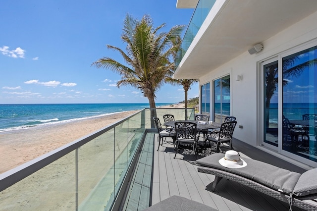 balcony featuring a beach view and a water view