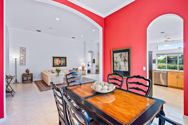 tiled dining area with ceiling fan and crown molding