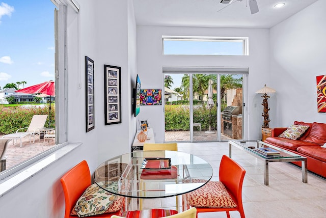 dining room with light tile floors, a high ceiling, and ceiling fan