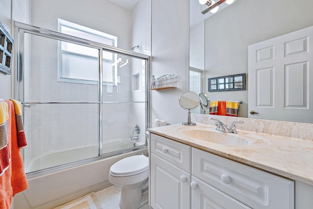 full bathroom featuring tile floors, enclosed tub / shower combo, toilet, and vanity