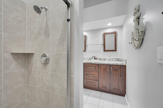 bathroom with a tile shower, tile flooring, and large vanity