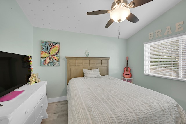 bedroom with light hardwood / wood-style floors, ceiling fan, and lofted ceiling