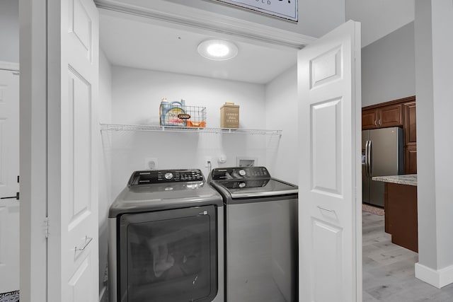 washroom with hookup for a washing machine, washer and dryer, light hardwood / wood-style floors, and electric dryer hookup