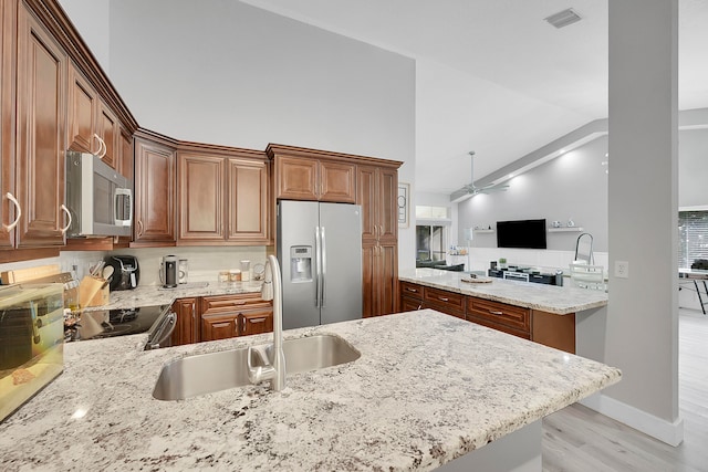 kitchen with ceiling fan, light hardwood / wood-style flooring, kitchen peninsula, stainless steel appliances, and sink