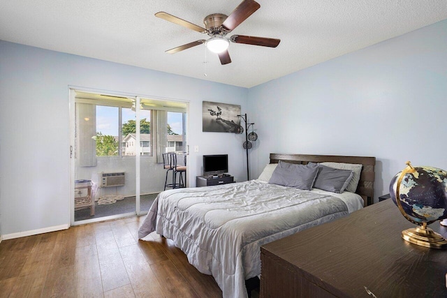 bedroom with dark hardwood / wood-style floors, a textured ceiling, ceiling fan, and an AC wall unit