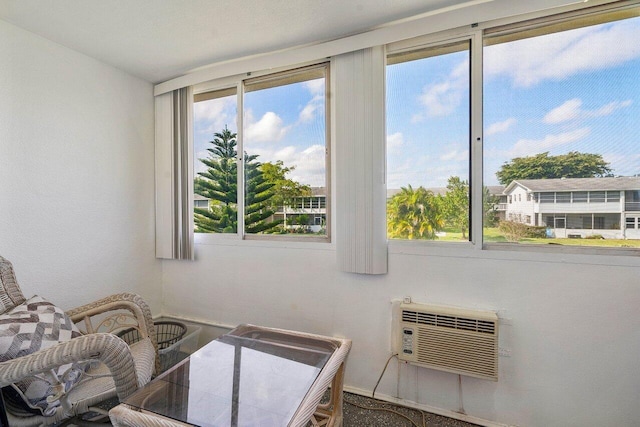 bedroom with an AC wall unit and multiple windows