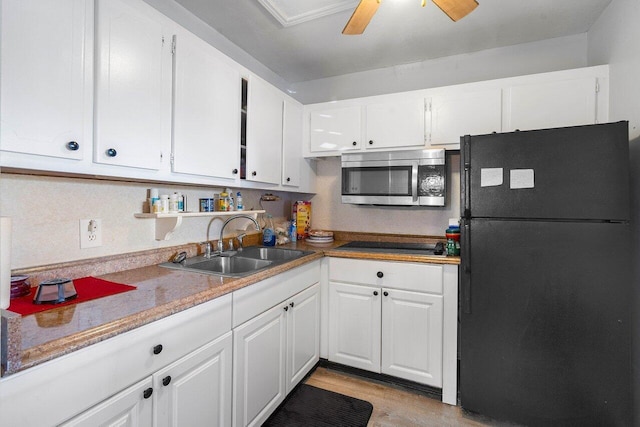 kitchen featuring light wood-type flooring, ceiling fan, black appliances, and white cabinetry