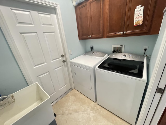 washroom with cabinets, independent washer and dryer, sink, and light tile patterned floors