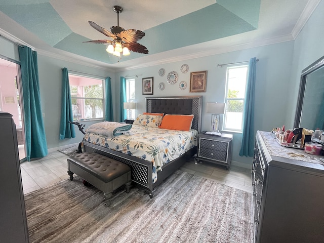 bedroom featuring a tray ceiling, ceiling fan, tile patterned flooring, and ornamental molding